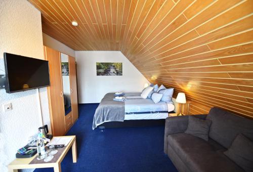 a hotel room with a bed and a couch at Hotel Wappenhof in Braunlage