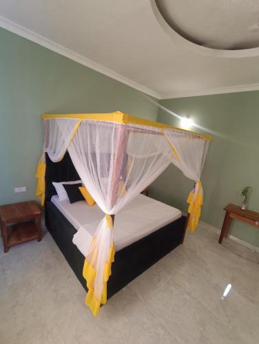 a bedroom with a bed with a canopy at B&B G&H house Zanzibar in Pingwe