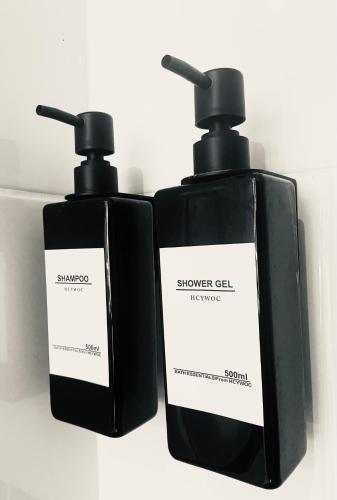 two bottles of soap sitting next to each other at La maison du 1, Vexin in Gaillon-sur-Montcient