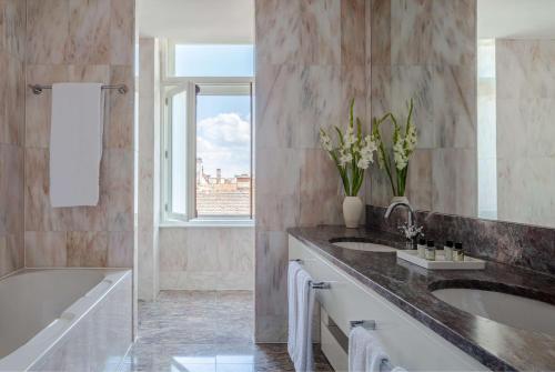 a bathroom with two sinks and a bath tub at Anantara New York Palace Budapest - A Leading Hotel of the World in Budapest