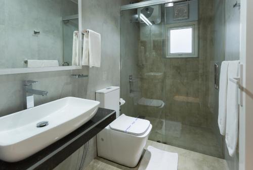 a bathroom with a sink and a toilet and a shower at Hotel Grand Turf By GSP in Nuwara Eliya