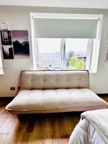 a couch in a room with a large window at Moderno y equipado departamento in Osorno