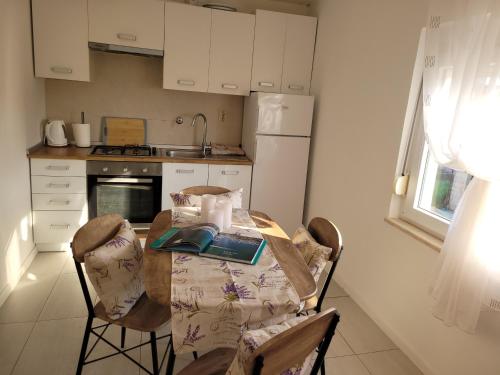a kitchen with a table and chairs and a kitchen with a refrigerator at Ferienwohnung Istrien 200m Strand in Fažana