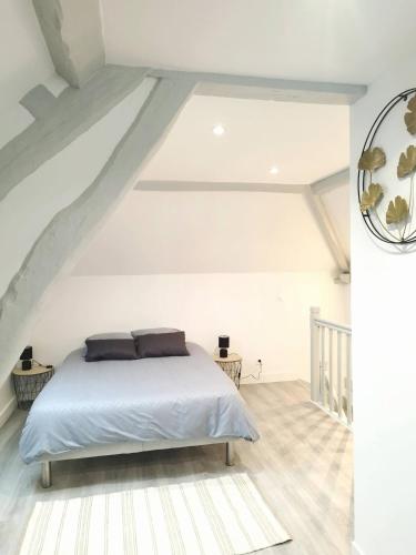 - une chambre blanche mansardée dans l'établissement La petite maison, à Therdonne