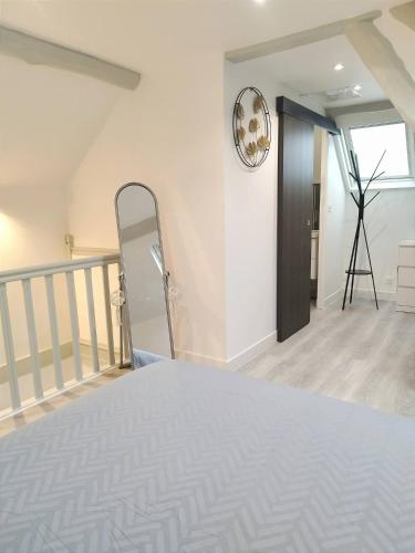 une chambre avec un lit blanc et un escalier dans l'établissement La petite maison, à Therdonne