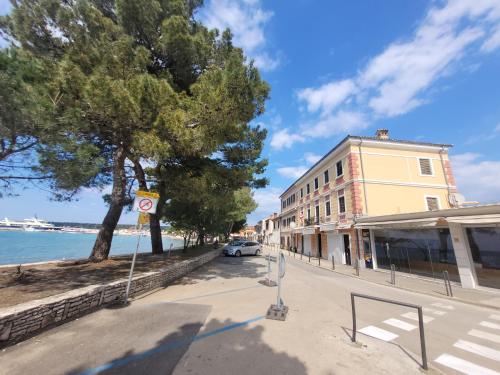 a street with a building next to the ocean at Ferienwohnung Istrien 200m Strand in Fažana