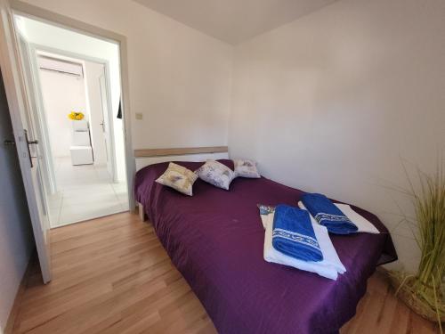 a bedroom with a purple bed with towels on it at Ferienwohnung Istrien 200m Strand in Fažana