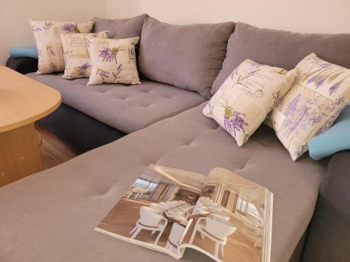a living room with a gray couch with pillows at Ferienwohnung Istrien 200m Strand in Fažana