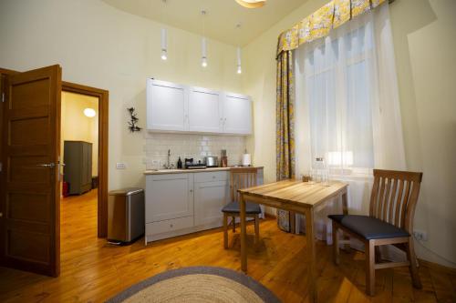 a kitchen with a table and chairs and a kitchen with white cabinets at Rainforest Studio Downtown by Pretty Apartments in Bucharest