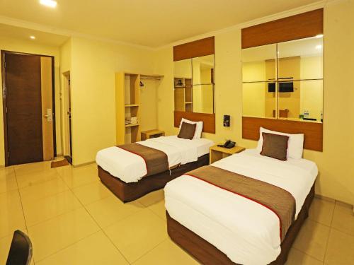 Postel nebo postele na pokoji v ubytování Super OYO Townhouse OAK Hotel Fiducia Serpong