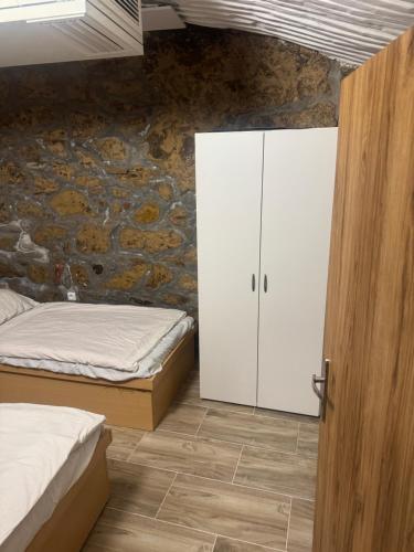 a bedroom with two beds and a white cabinet at Suterénní byt na Hejtmánce v Mladé Boleslavi u letiště in Mladá Boleslav