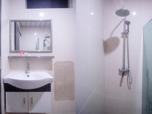 a white bathroom with a sink and a mirror at Hotel O Mayfair Hotel in Kuching