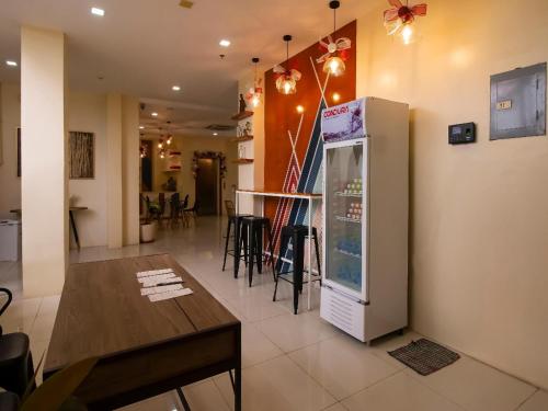 a kitchen and dining room with a refrigerator and a table at Super OYO 832 The Teepee Place Hostel & Residence Inn in Cebu City