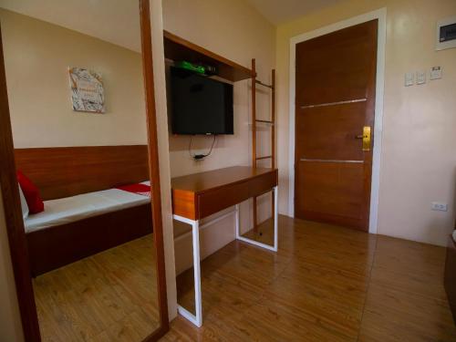 a small room with a tv and a door and a room at Super OYO 832 The Teepee Place Hostel & Residence Inn in Cebu City
