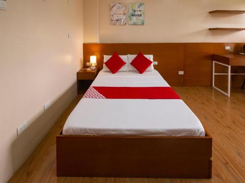 a bedroom with a large bed with red pillows at Super OYO 832 The Teepee Place Hostel & Residence Inn in Cebu City