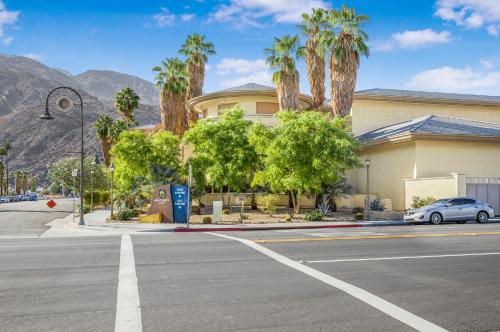 a car parked in front of a building with palm trees at Plaza Villas Getaway - 1br Downtown PS in Palm Springs