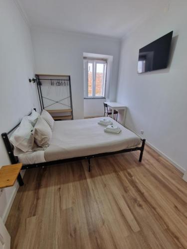 a large bed in a room with a wooden floor at Wolley - Peniche GuestHouse in Peniche