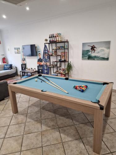 a pool table with cuesticks on top of it at Wolley - Peniche GuestHouse in Peniche