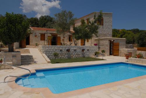 a swimming pool in front of a house at Agrotiko Traditional Houses in Kallepia