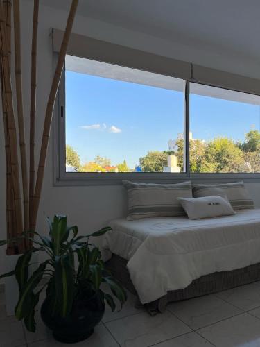 a bedroom with a bed and a large window at Edificio Farfalle -Cochera incuida in La Plata