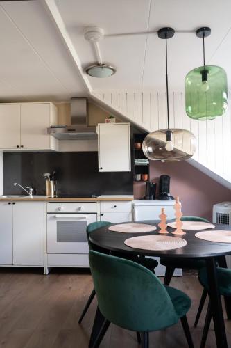 a kitchen with a table and some green chairs at Il Forno in Valkenburg