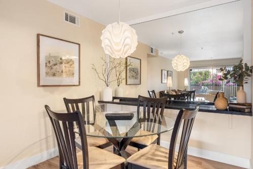 a dining room with a glass table and chairs at 1BR Plaza Villas Bliss - Downtown PS in Palm Springs