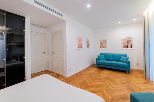 a bedroom with a blue chair and a bed at Neró Rooms in Taormina
