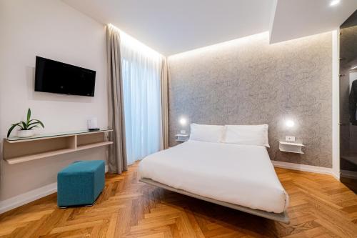 a hotel room with a bed and a tv at Neró Rooms in Taormina