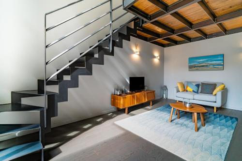 - un salon avec un escalier, un canapé et une table dans l'établissement Magnifique maison 7BR - Casino Deauville, à Deauville