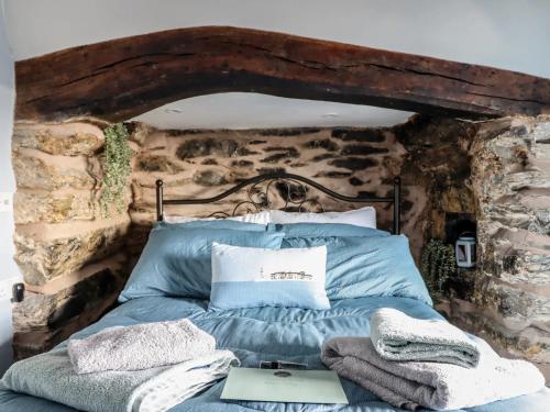 Bett in einem Zimmer mit einer Steinmauer in der Unterkunft Top Cottage Barmouth in Barmouth