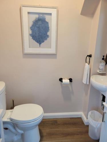 a white bathroom with a toilet and a sink at Waterfront Salt Pond House, water view and dock in Charlestown