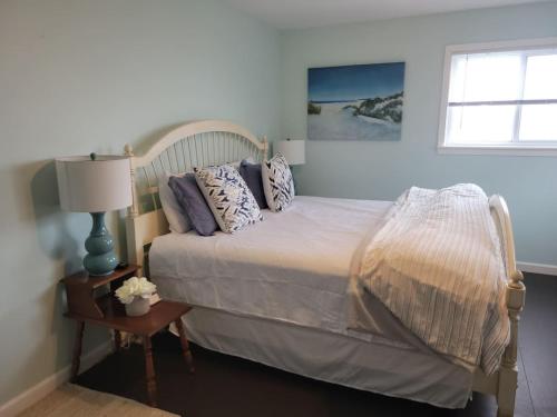 a bedroom with a bed with pillows and a window at Waterfront Salt Pond House, water view and dock in Charlestown