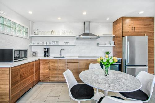 a kitchen with a table and chairs and a refrigerator at Ocotillo Art Lounge - 1BR Posh Condo in South PS in Palm Springs