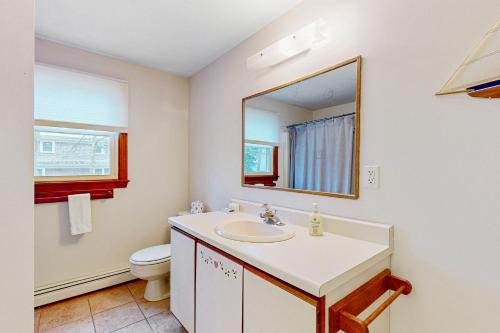 a bathroom with a sink and a toilet and a mirror at Skylight Tonight in South Dennis