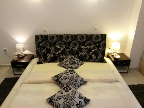 Una cama grande con almohadas blancas y negras. en Studio Kairos, en Trogir