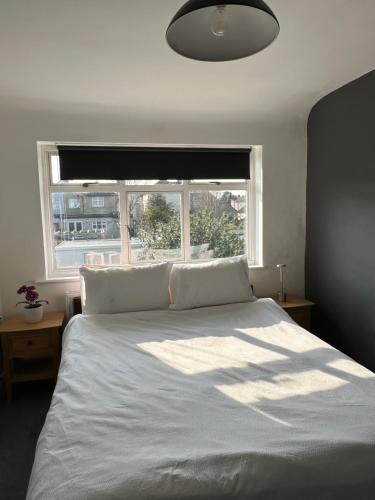 a bedroom with a large white bed with a window at Top House Sidcup in Streatham Hill