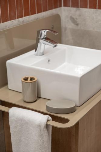 a white bathroom sink on a counter with towels at Desert 2 bedrooms apartment in Gemmayze in Ar Rumayl