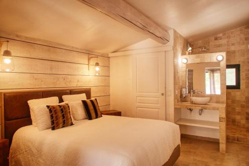 Un dormitorio con una cama blanca y un lavabo. en Le Hameau Fleur de Pierres , Chambre , Gite et Table d'Hôtes, en Murs