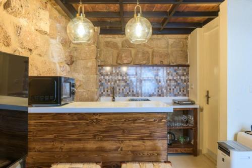 a kitchen with a sink and a microwave at Arcades 1 de Bahsa in Batroûn