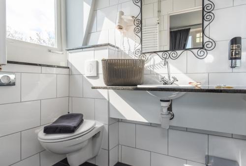 a bathroom with a toilet and a sink and a mirror at Villahotel Vlissingen in Vlissingen