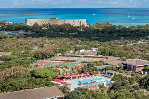 an aerial view of a resort with a pool and the ocean at Club Esse Sporting in Stintino