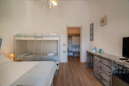 a bedroom with a bunk bed and a television at Club Esse Sporting in Stintino