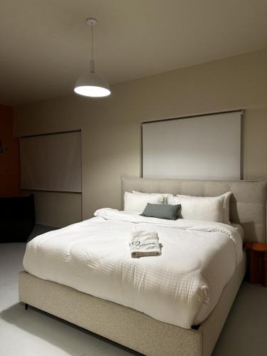 a bedroom with a large white bed with a towel on it at Bond 3BR Sin El Fil in Beirut