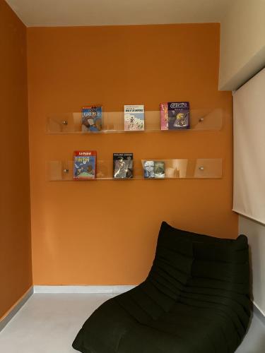 a room with orange walls and a couch and books at Bond 3BR Sin El Fil in Beirut