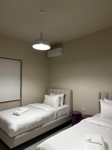 two beds sitting next to each other in a room at Bond 3BR Sin El Fil in Beirut