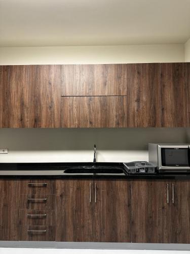 a kitchen with a sink and a microwave at Bond 3BR Sin El Fil in Beirut