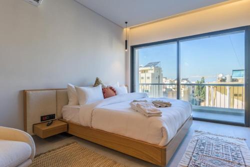 a bedroom with a large bed and a large window at BOHO Studio Wanderwood in Mar Mikhael in Beirut