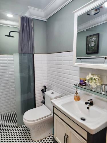 a bathroom with a toilet and a sink and a mirror at DRimba 3BR 1-7PX Pool & Near MRT Kota Damansara in Petaling Jaya