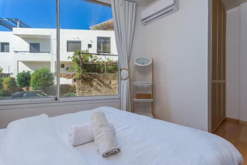 a bedroom with a white bed and a large window at Exquisite Apartment in Bahsa, Batroun 2BR in Batroûn