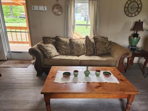 a living room with a couch and a coffee table at Pop's Place -Lakeview 3bd 2 ba on 6 acres in Fort Gibson